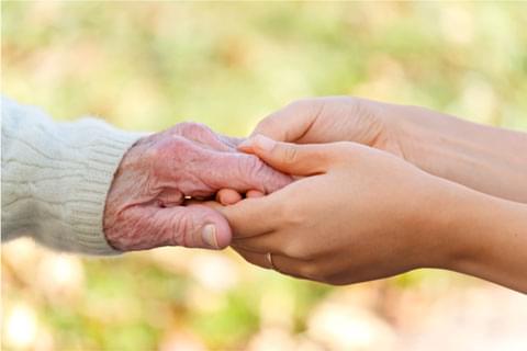 Hands holding older person's hands