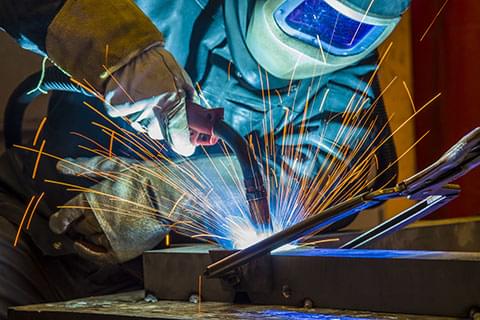 Worker welding an object