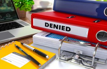 office supplies and a red file with the "denied" inscription